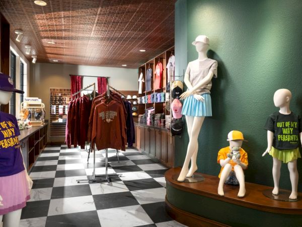 A clothing store display with mannequins in colorful outfits, racks of apparel, and a checkered floor, bright and stylish ambience.