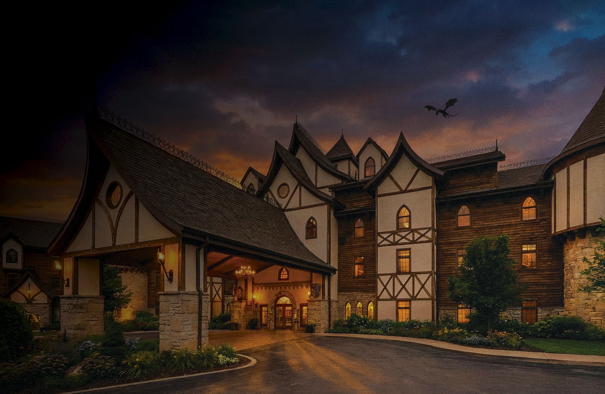 A large Tudor-style hotel with timber-framed walls, stone accents, and a curved driveway at dusk, warm lights glowing from windows under a dramatic sky.