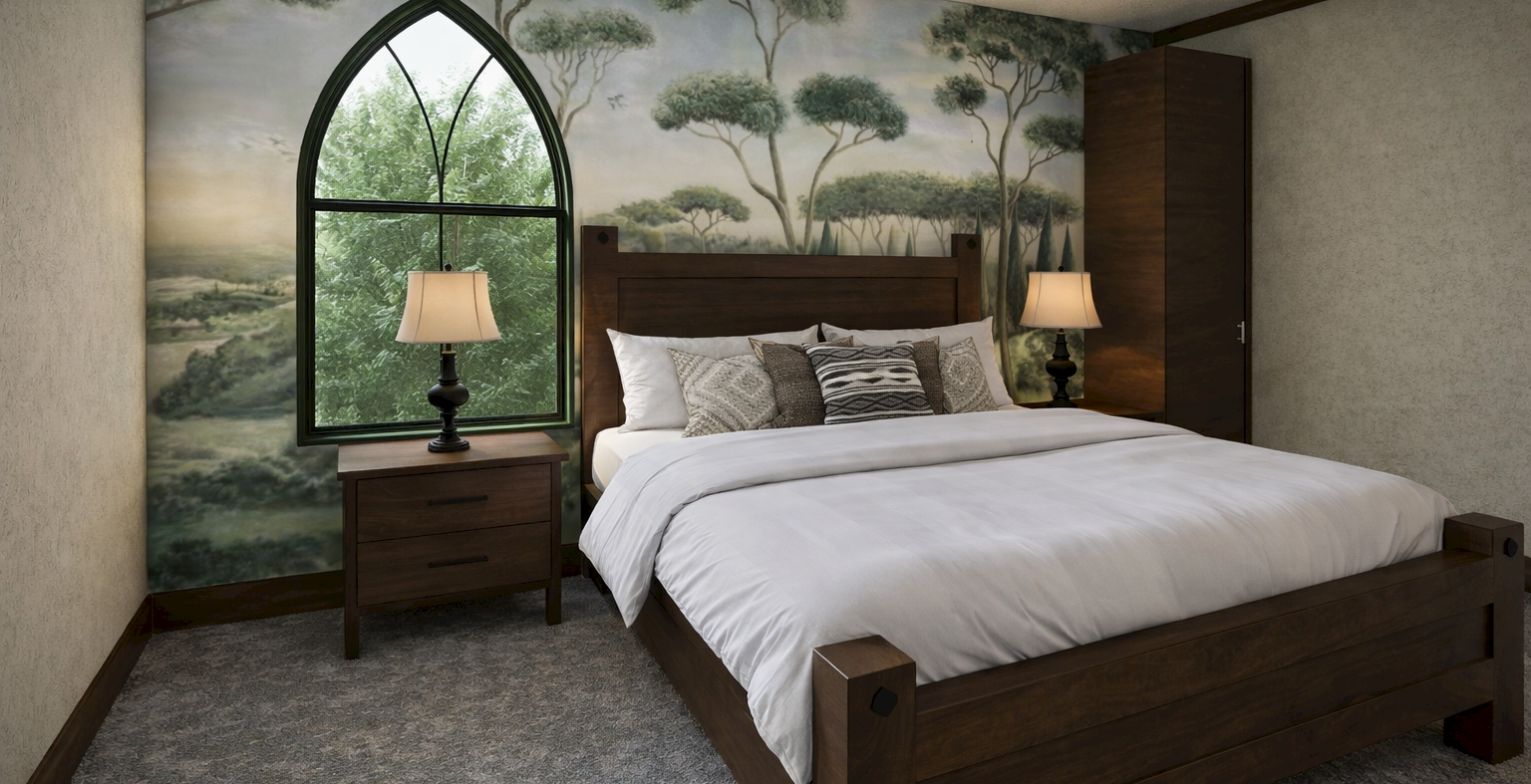 A cozy hotel room with a large wooden bed, two matching nightstands, lamps, a mural of trees on the wall, and a tall arched window beside the bed.