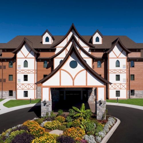 A grand, castle-like hotel with peaked, white-trimmed roofs, stone towers, and a curved drive leading to a welcoming entrance. (ends with a period)