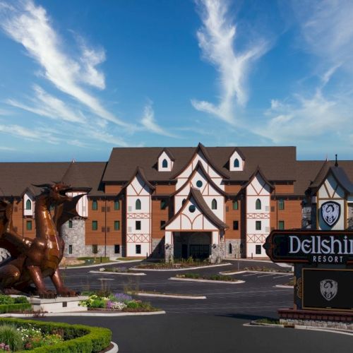 A large, lodge-like hotel with brown roofs and white walls, a horse statue in the plaza, and a sign reading &ldquo;Dellsphere&rdquo; in front.