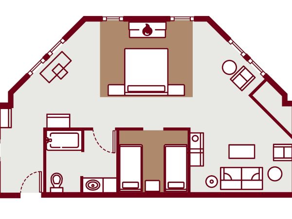 A top-down floor plan of a bedroom suite with a central bed, two desks, seating areas, and a bathroom, surrounded by angled outer walls.