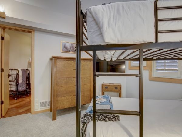 Bright bedroom showing a metal canopy bed and open doorway with wood trim.